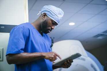 Ernsthafte schwarze Krankenschwester mit digitaler Tafel - BLEF00879