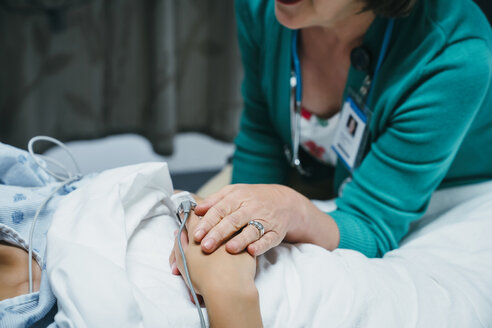Kaukasischer Arzt tröstet Patient im Krankenhausbett - BLEF00891