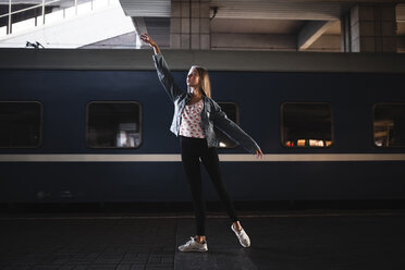 Caucasian woman dancing near train - BLEF00939