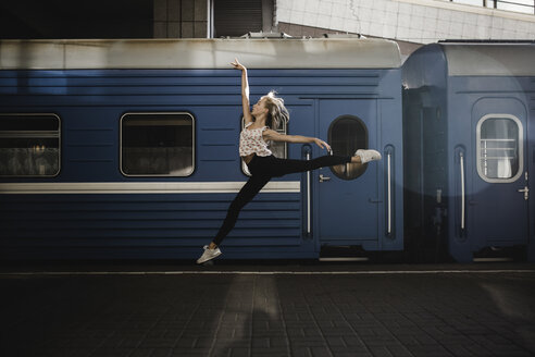 Caucasian woman dancing near train - BLEF00941