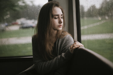 Pensive Caucasian woman sitting on bus in rain - BLEF00945