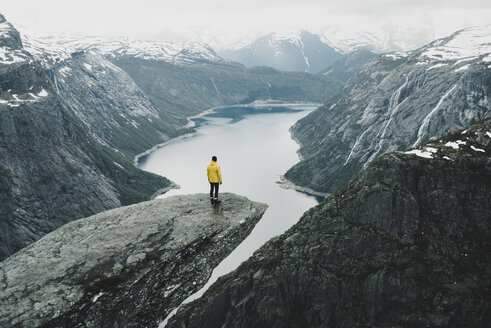 Caucasian man on cliff admiring scenic view of mountain river - BLEF01129