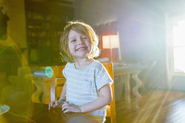 Sonnenschein auf einem kaukasischen Jungen, der am Tisch sitzt - BLEF01173