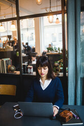 Selbstbewusste Geschäftsfrau mit Laptop am Schreibtisch im Kreativbüro - MASF11890