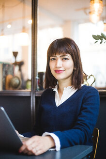 Portrait of confident female professional sitting with laptop at office - MASF11971