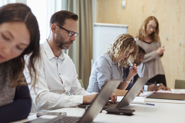 Geschäftskollegen arbeiten am Laptop am Konferenztisch im Büro - MASF12015