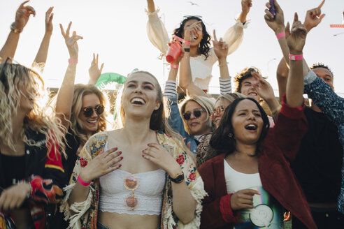 Glückliche Männer und Frauen genießen Musik bei einem Konzert im Sommer - MASF12045