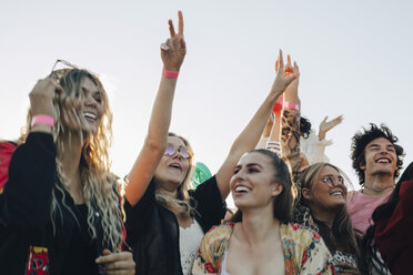 Cheerful people enjoying music concert against sky in summer - MASF12046