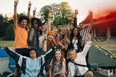 Porträt von fröhlichen jungen Freunden beim Zelten während eines Festivals - MASF12049