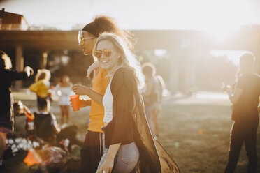 Smiling woman walking with friend at concert - MASF12068