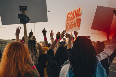 Rückansicht junger Frauen, die für Gleichberechtigung protestieren, während sie durch die Stadt marschieren - MASF12089