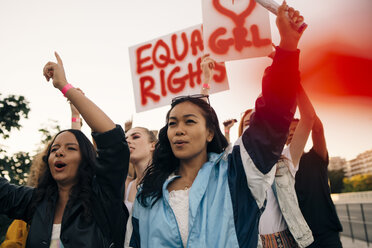 Frauen mit Transparenten protestieren gemeinsam für gleiche Rechte gegen den Himmel - MASF12090