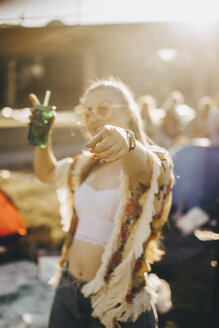 Junge Frau mit Getränk, die sich bei einer Musikveranstaltung amüsiert - MASF12101