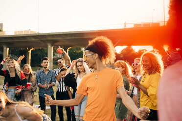 Mann genießt beim Tanzen mit Freunden bei einer Musikveranstaltung im Sommer - MASF12114