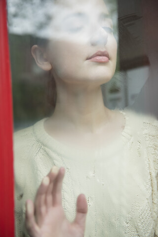 Kaukasische Frau träumt hinter einem nebligen Fenster, lizenzfreies Stockfoto