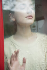 Caucasian woman daydreaming behind foggy window - BLEF01176