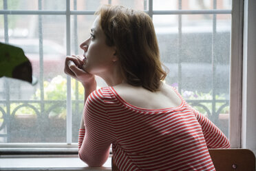 Pensive Caucasian woman daydreaming near window - BLEF01181