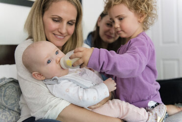Caucasian girl feeding bottle to baby sister - BLEF01213