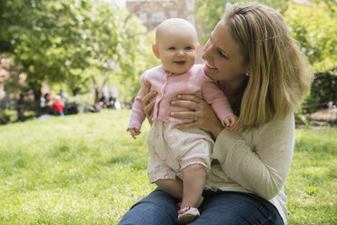 Portrait of Caucasian mother holding baby daughter in park - BLEF01225