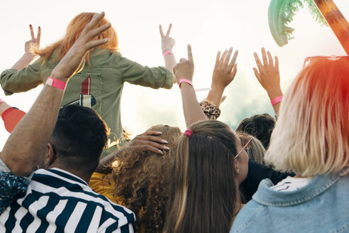 Rückansicht von begeisterten Fans, die ein Musikkonzert an einem sonnigen Tag genießen - MASF12159