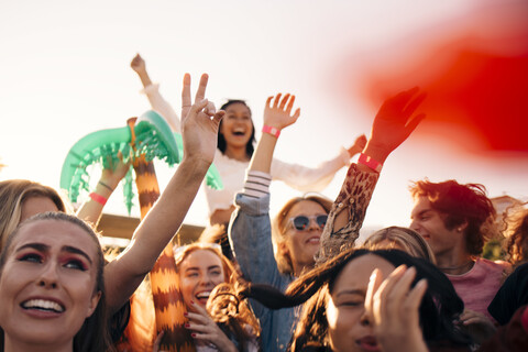 Glückliche Männer und Frauen, die ein Musikkonzert an einem sonnigen Tag genießen, lizenzfreies Stockfoto