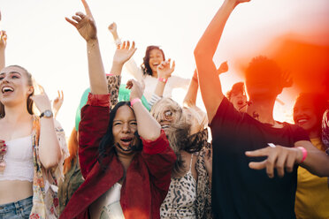 Multi-ethnic cheerful fans enjoying in music concert during sunny day - MASF12177