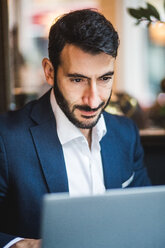 Confident male entrepreneur using laptop at creative office - MASF12251