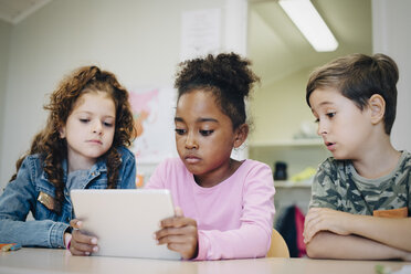 Schulfreunde lernen mit einem digitalen Tablet am Schreibtisch im Klassenzimmer - MASF12305