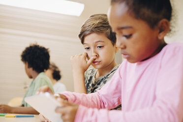 Jungen benutzen ein digitales Tablet beim Lernen im Klassenzimmer - MASF12309