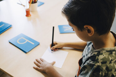 Hohe Winkel Ansicht der Schuljunge üben Alphabete am Tisch im Klassenzimmer - MASF12316