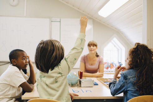 Schüler hebt die Hand und antwortet dem Lehrer im Klassenzimmer der Schule - MASF12317