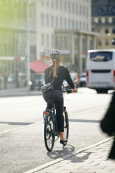 Volle Länge Rückansicht der jungen weiblichen Pendler Radfahren auf der Straße in der Stadt - MASF12332