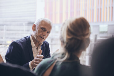 Confident mature businessman discussing with businesswoman during meeting at creative office - MASF12355