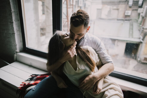 Caucasian couple kissing on window sill - BLEF01271