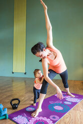 Mixed Race expectant mother practicing yoga and watching daughter - BLEF01285