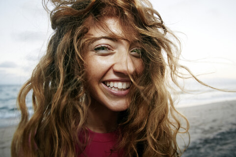 Wind weht Haare der kaukasischen Frau am Strand, lizenzfreies Stockfoto