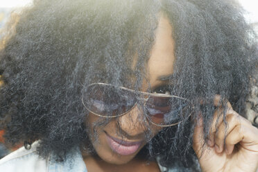 Close up of mixed race woman peering over sunglasses - BLEF01381