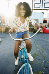 Lächelnde gemischtrassige Frau fährt Fahrrad - BLEF01392
