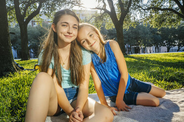 Portrait of smiling Caucasian girls on blanket in park - BLEF01410