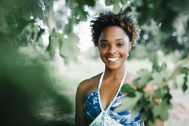 Portrait of smiling mixed race woman near tree - BLEF01466