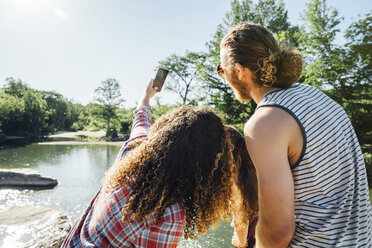 Freunde posieren für ein Handy-Selfie am Fluss - BLEF01540