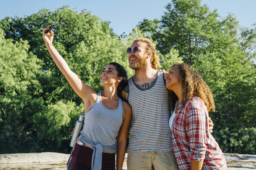 Friends posing for cell phone selfie outdoors - BLEF01541
