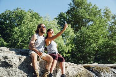 Kaukasisches Paar posiert für Handy-Selfie auf Felsen - BLEF01547