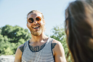 Kaukasischer Mann mit Brusttattoo, der im Freien lacht - BLEF01553