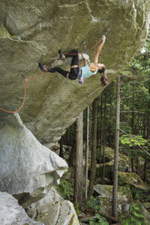 Gemischtrassiges Mädchen klettert auf Felsen - BLEF01585