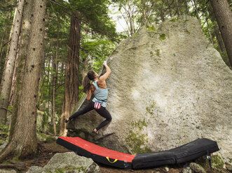 Gemischtrassiges Mädchen klettert auf Felsen - BLEF01586