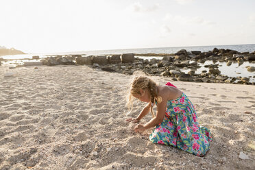 Caucasian girl playing in sand at beach - BLEF01588