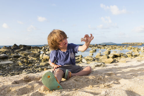 Kaukasischer Junge, der am Strand im Sand spielt - BLEF01589