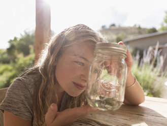 Kaukasisches Mädchen schaut in ein Glas - BLEF01596