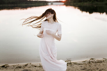 Caucasian woman tossing hair on beach - BLEF01609